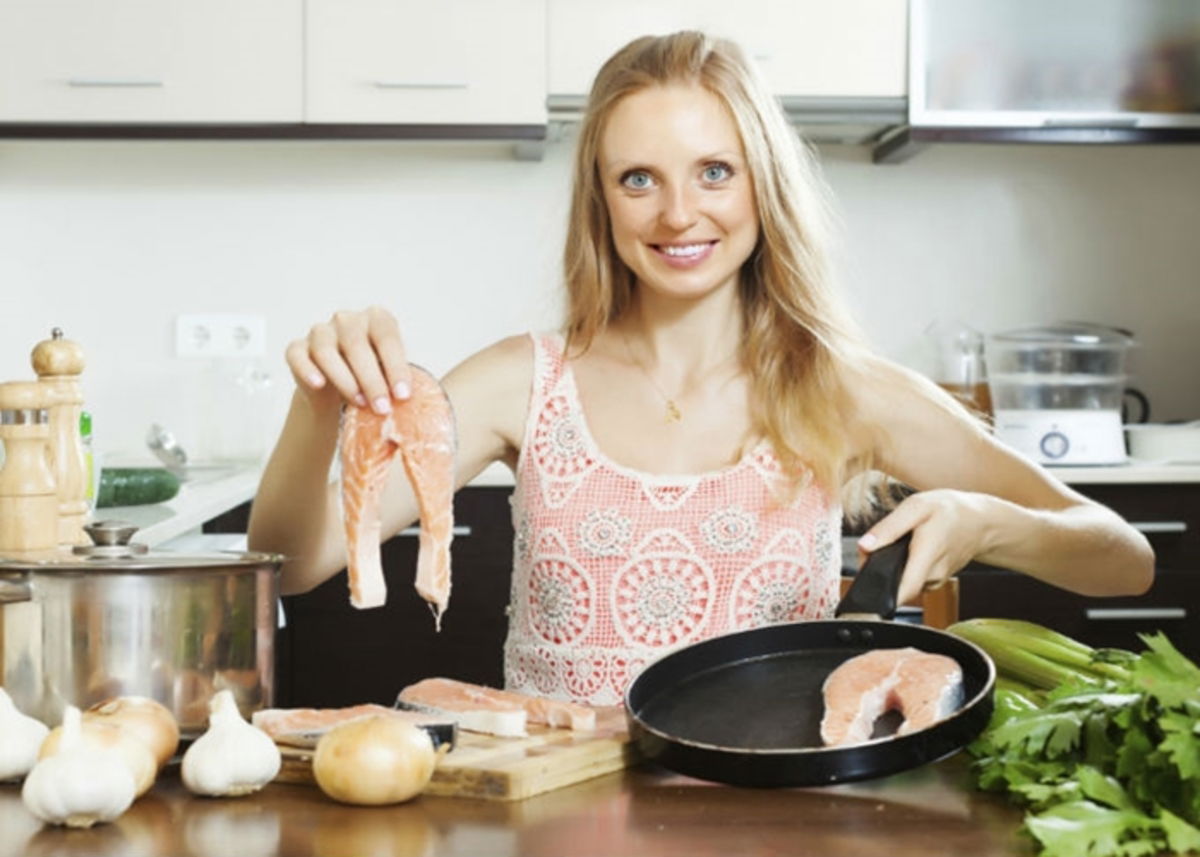 Mujer cocinando pescado
