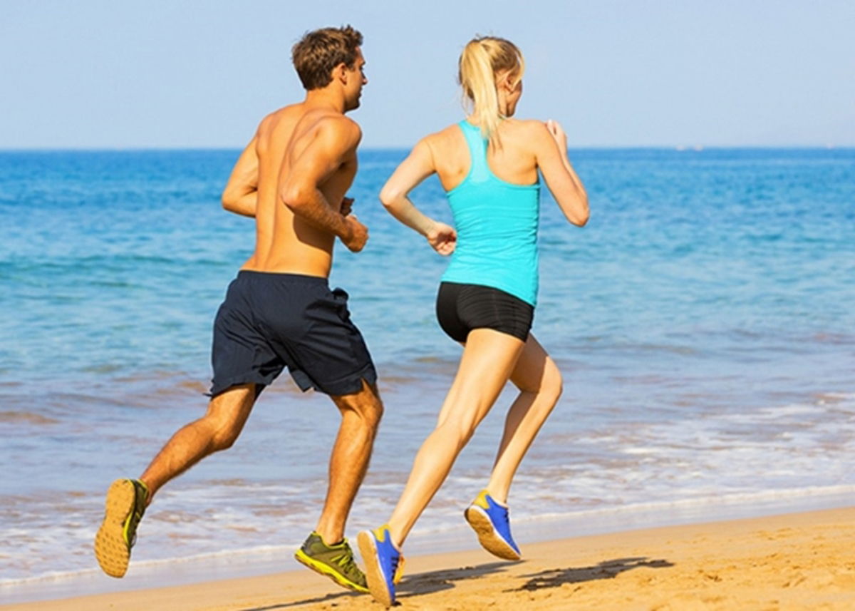 Pareja corriendo en la arena