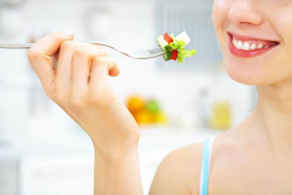 Mujer y comida en tenedor