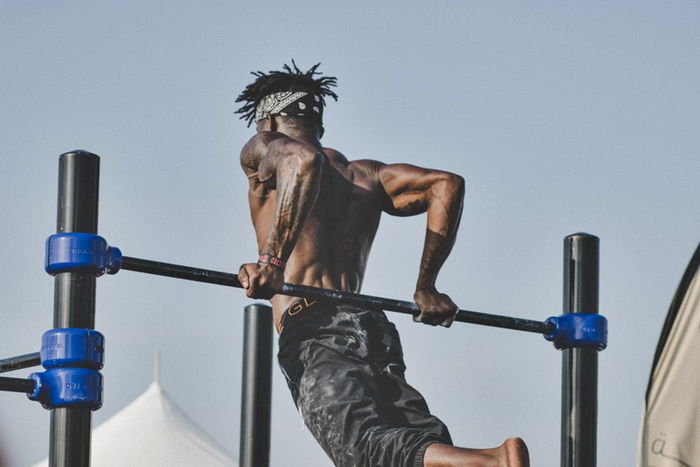 Chico haciendo fondos de tríceps en barra