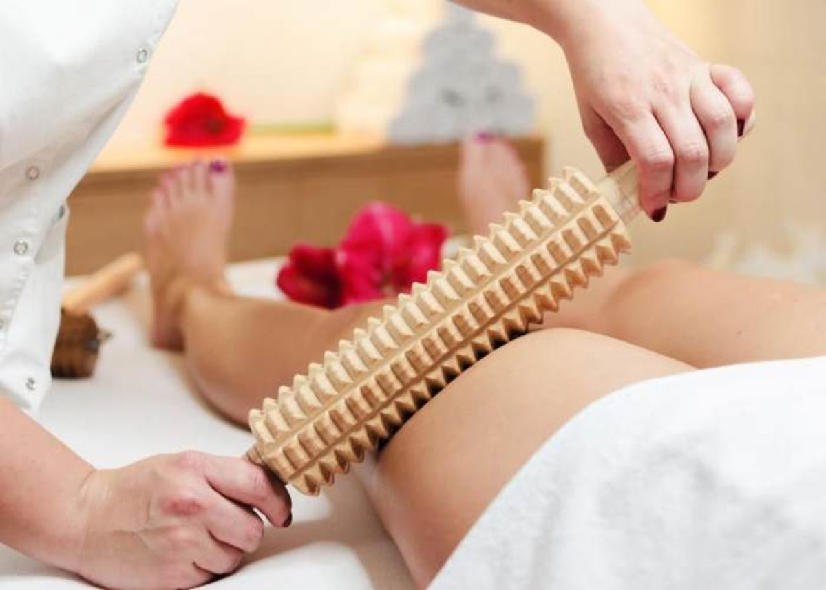 Mujer masaje con instrumento madera