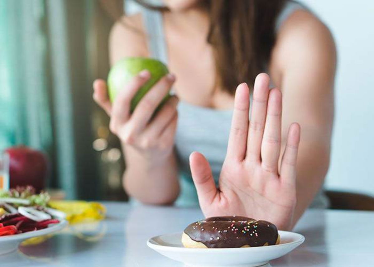 Mujer negándose a comer dona