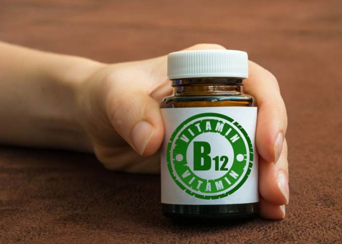 Mano con frasco vitamina B12