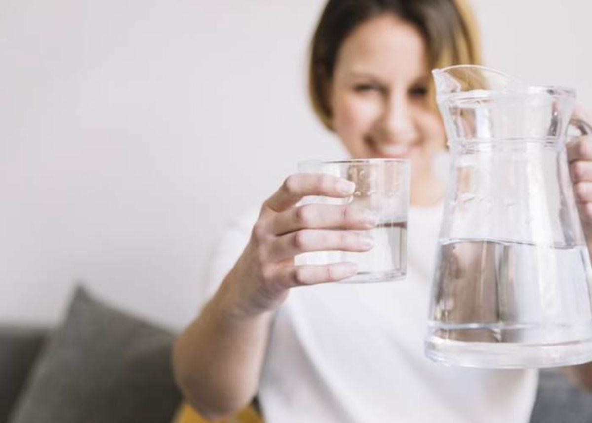 Mujer tomando jarra con agua