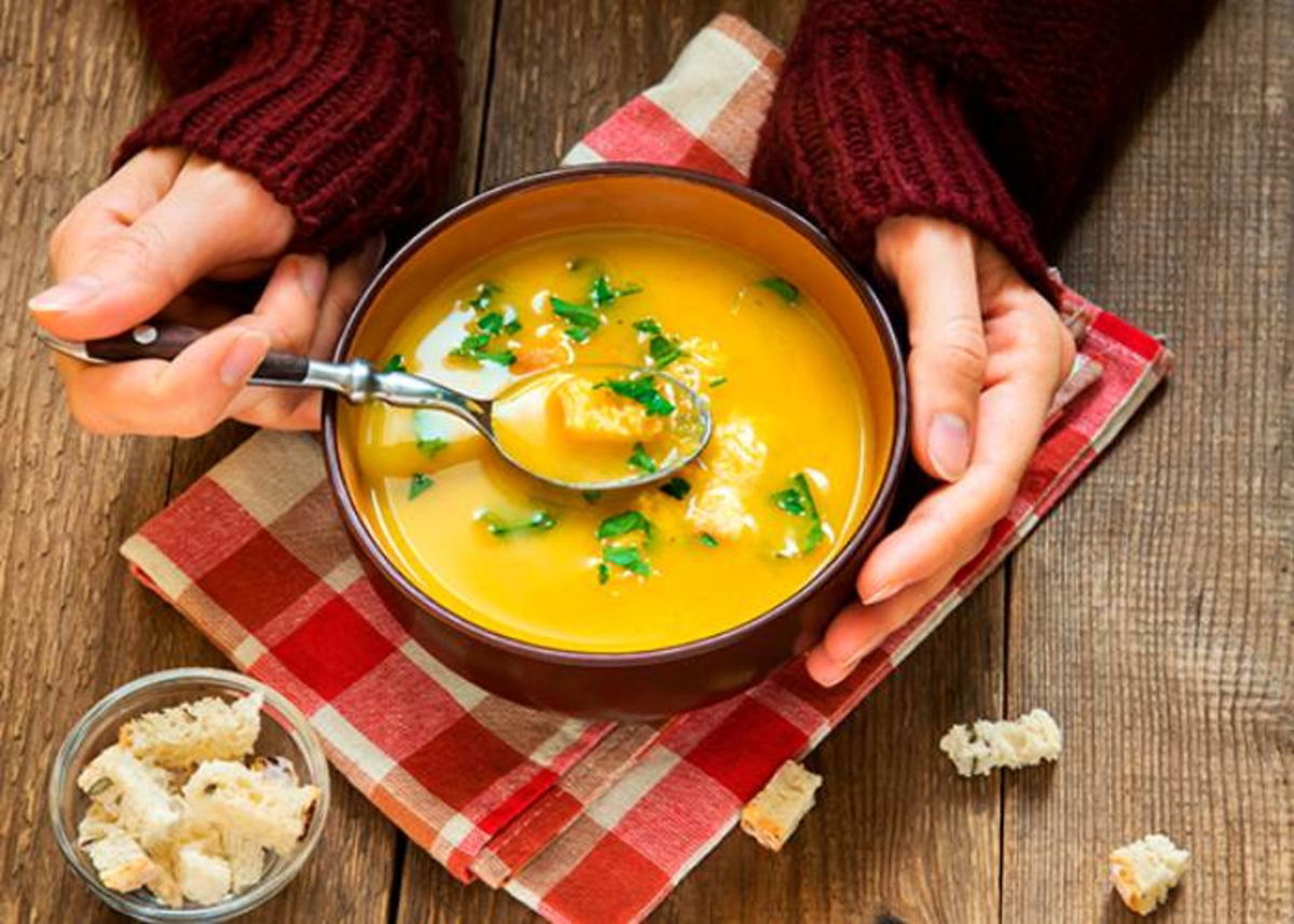 Manos tomando un tazón de sopa