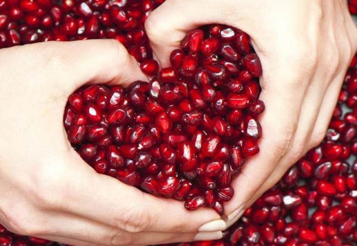 Manos formando corazón con granada