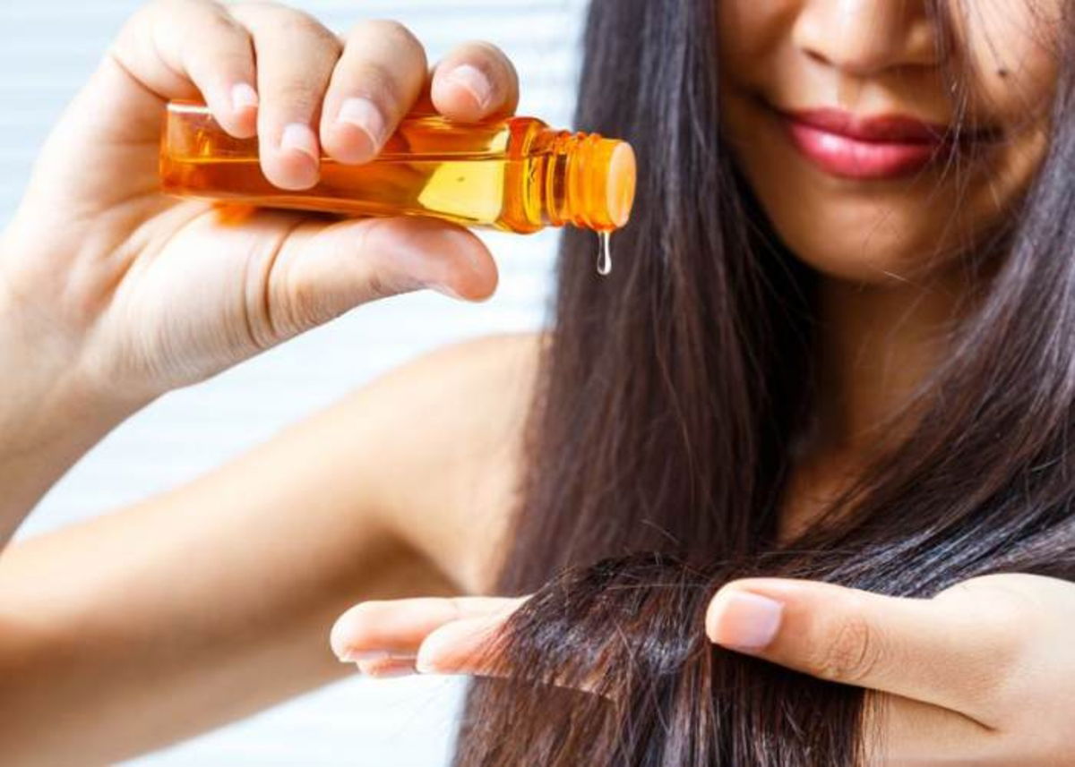 Mujer colocando aceite al cabello