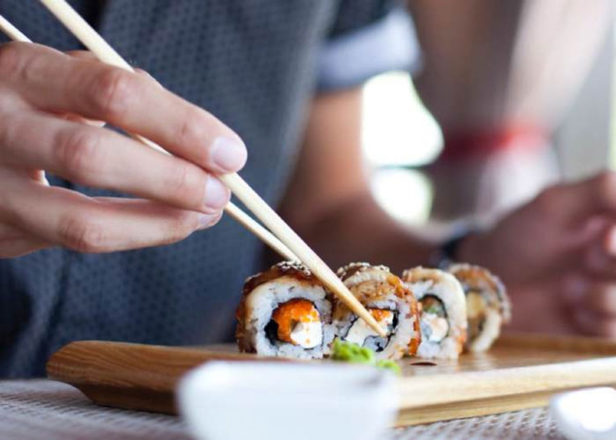 Persona tomando sushi