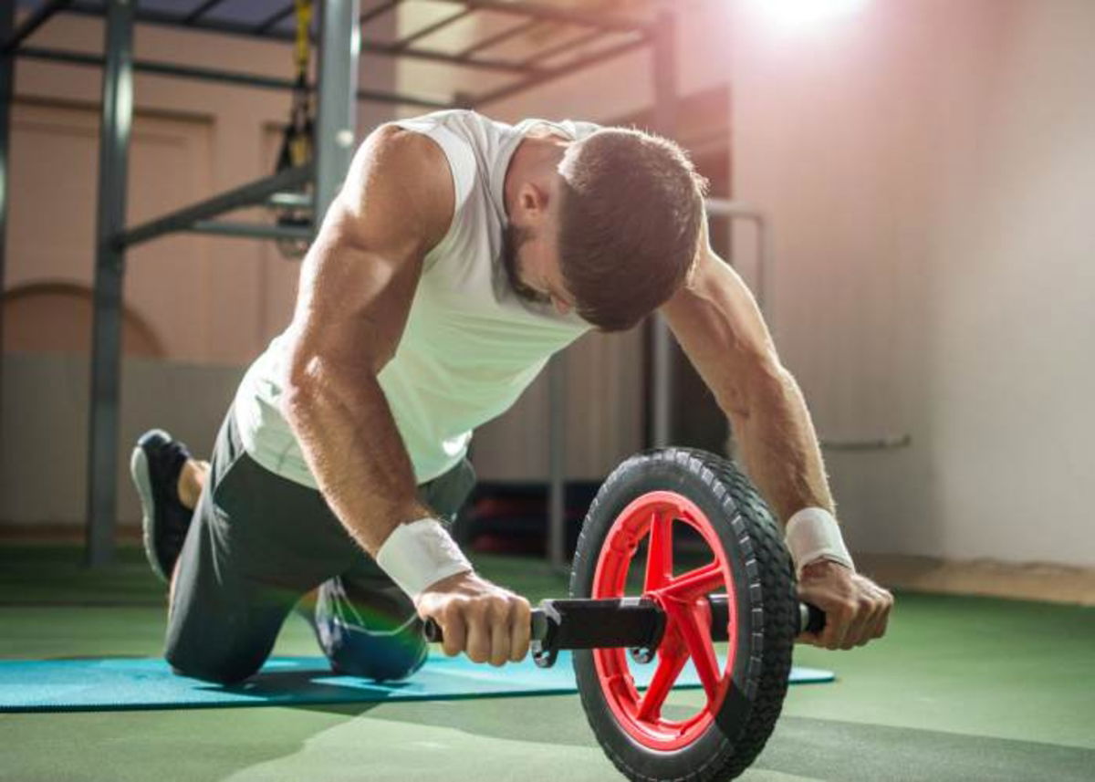 Hombre trabajando rueda abdominal