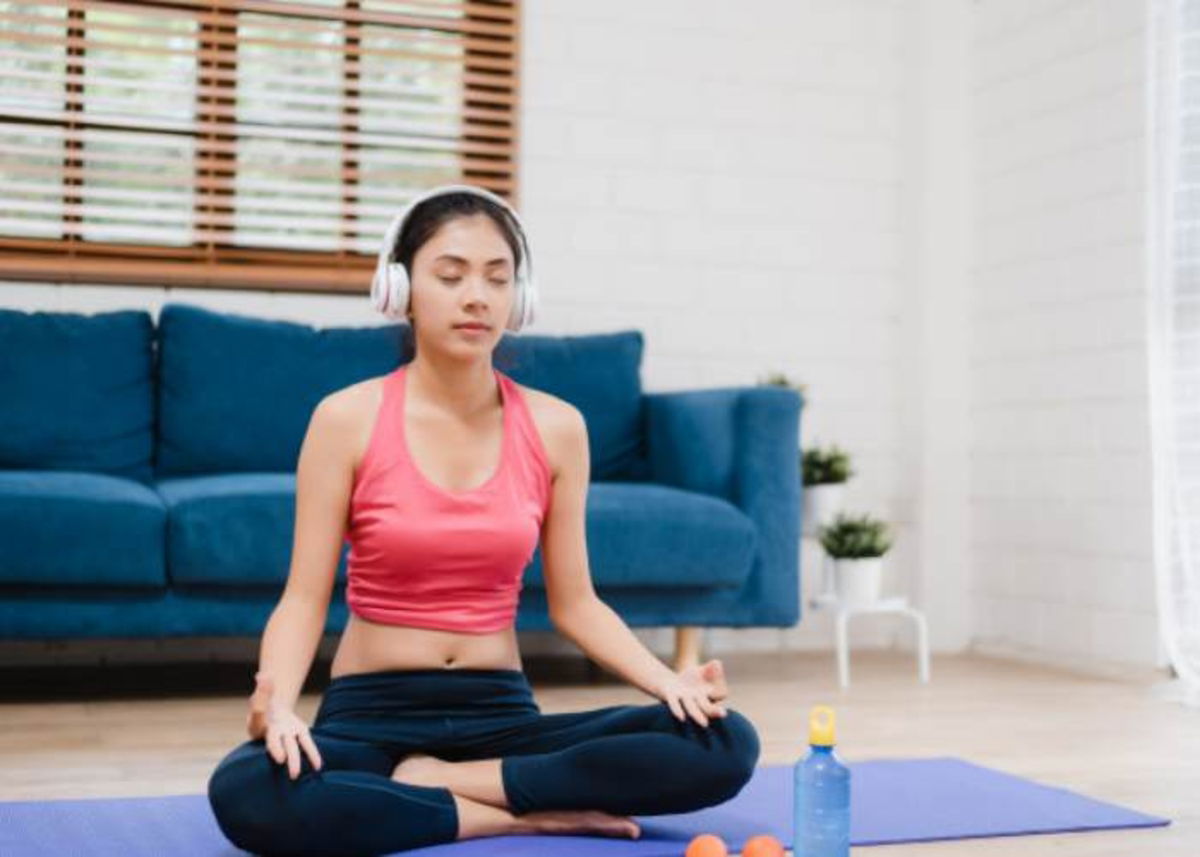 Mujer realizando Yoga con música