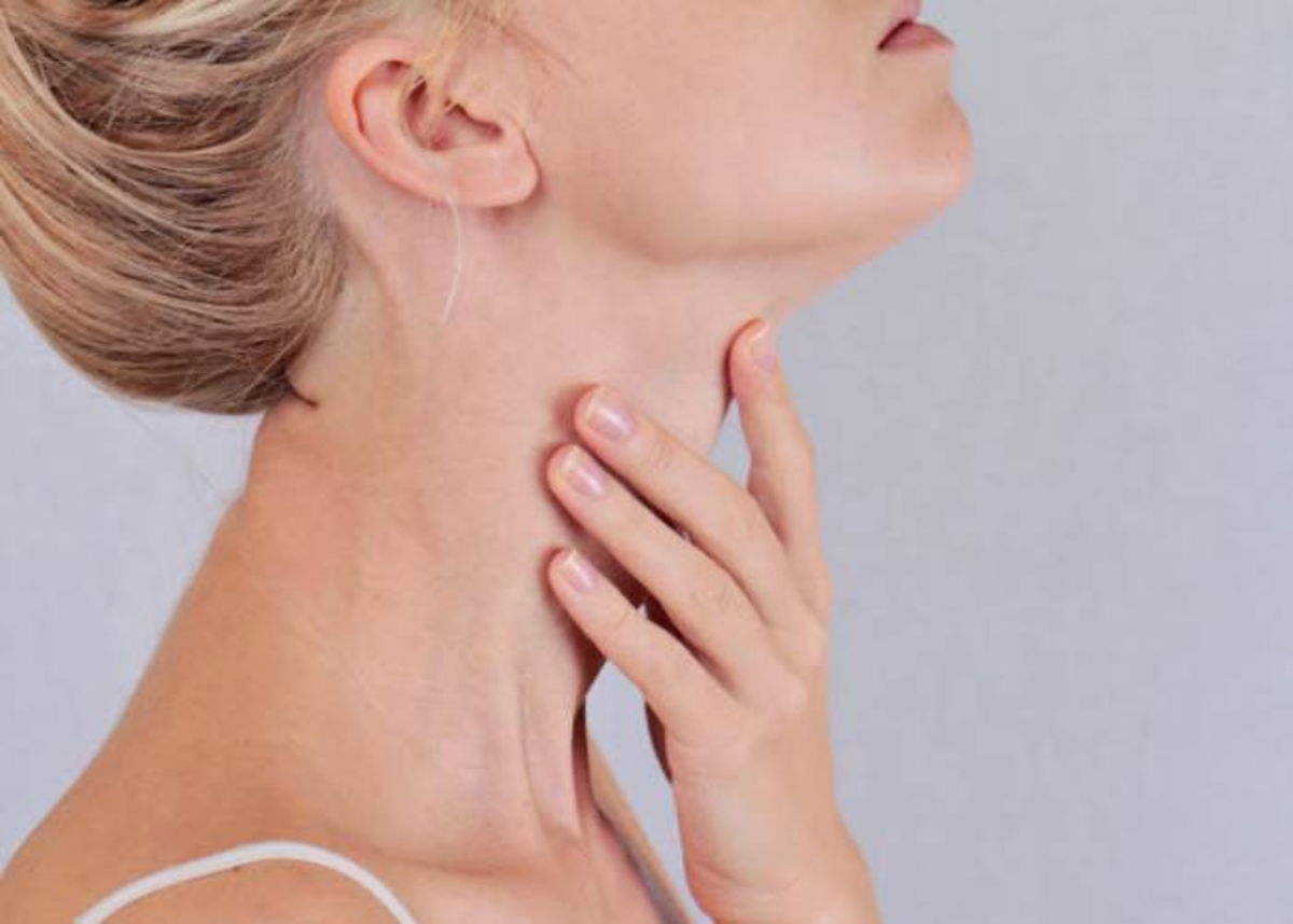 Mujer tocándose cuello