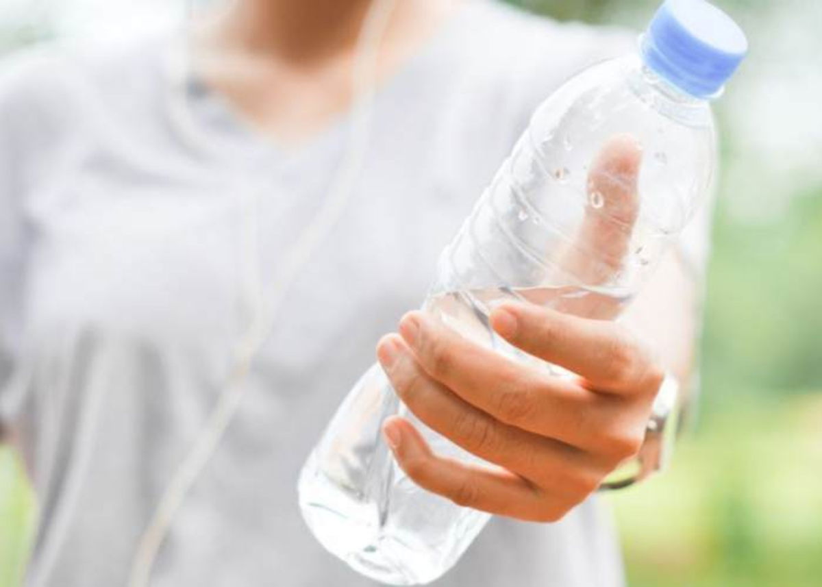 Persona con botella en mano