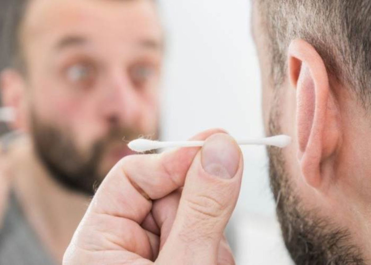 Hombre con hisopo en oído