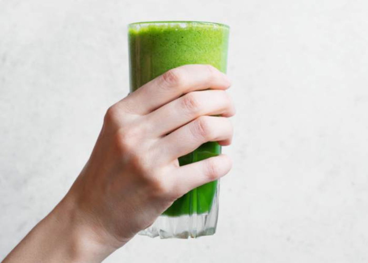 Mano tomando vaso con zumo