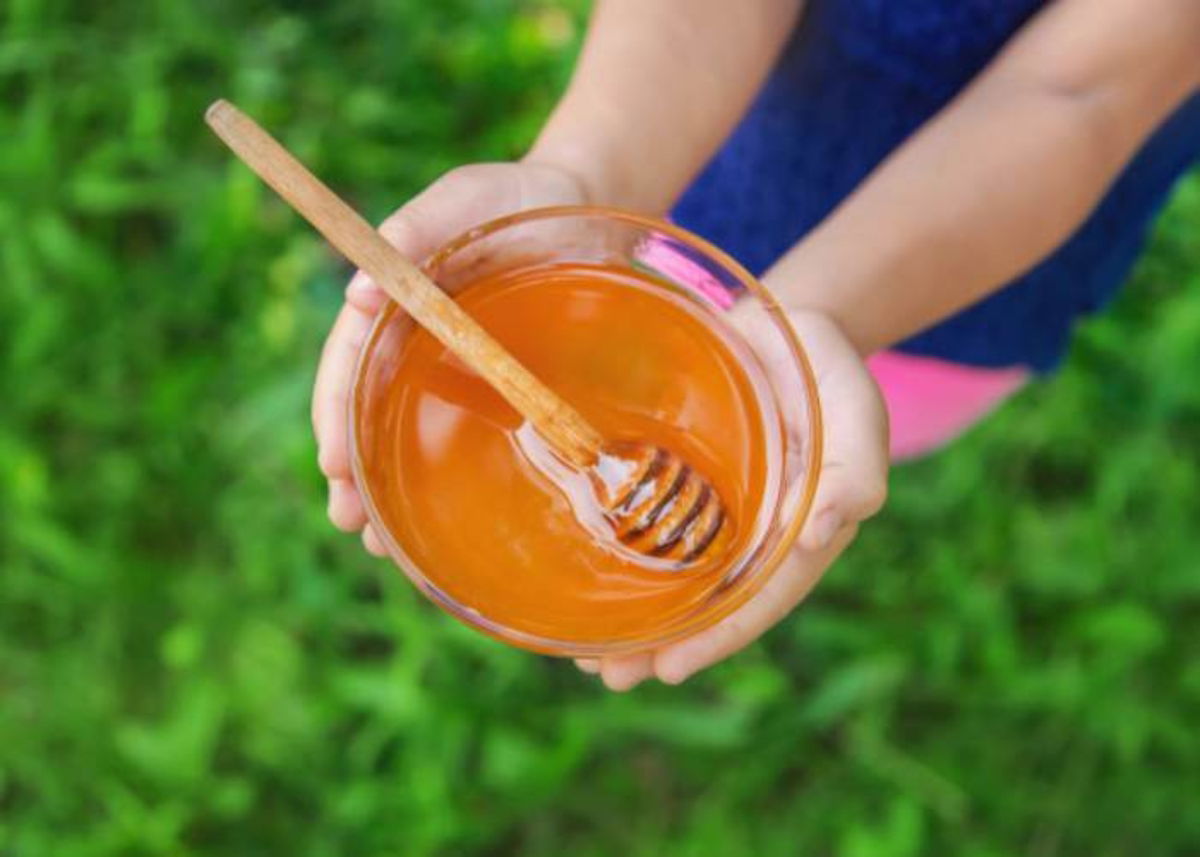 Persona tomando recipiente con miel
