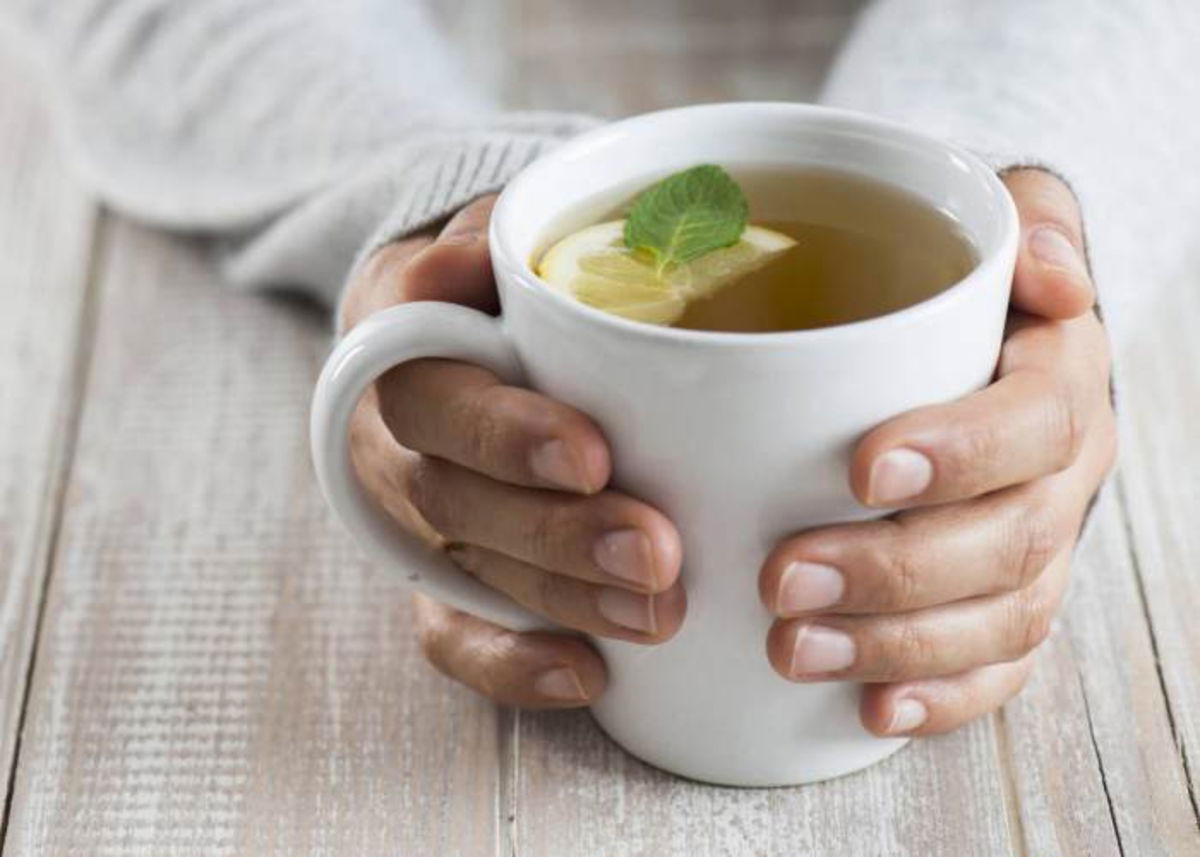 Persona tomando taza con infusión