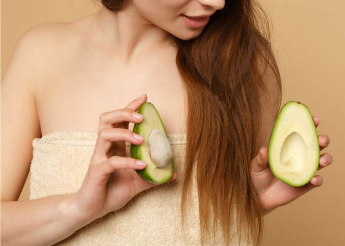 Mujer tomando mitades de aguacate