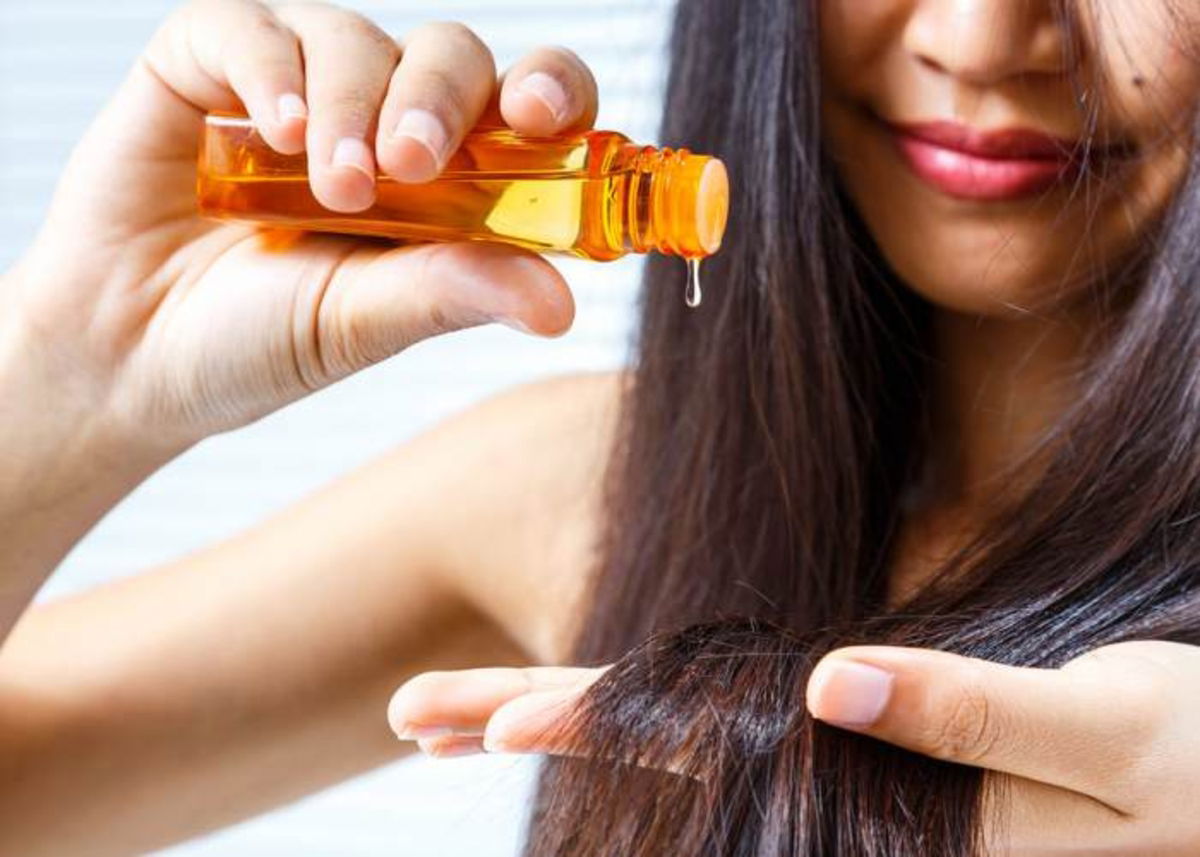 Mujer aplicando aceite cabello