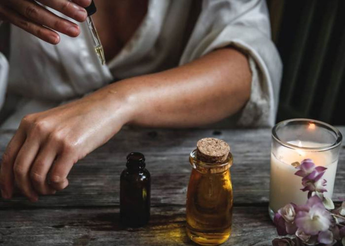 Persona colocando aceite de ricino negro cuerpo