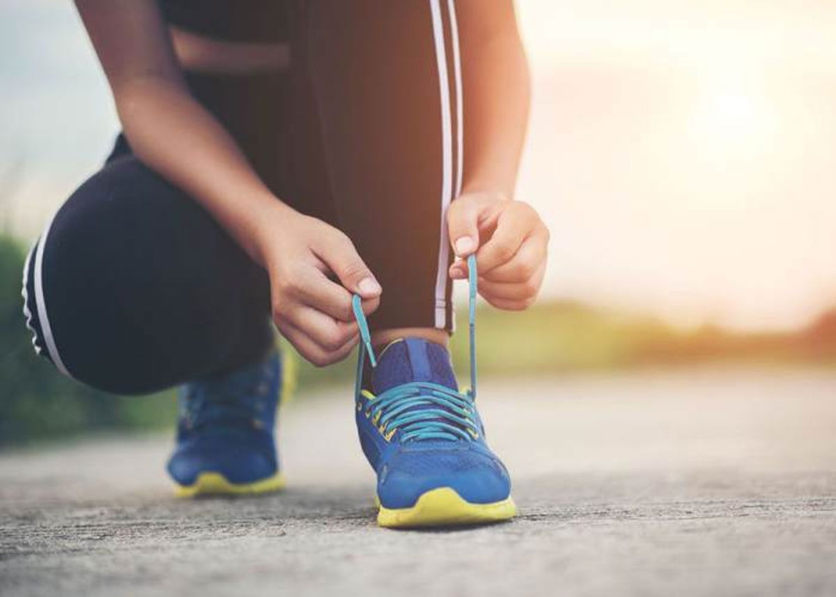 Persona atándose zapatillas deportivas