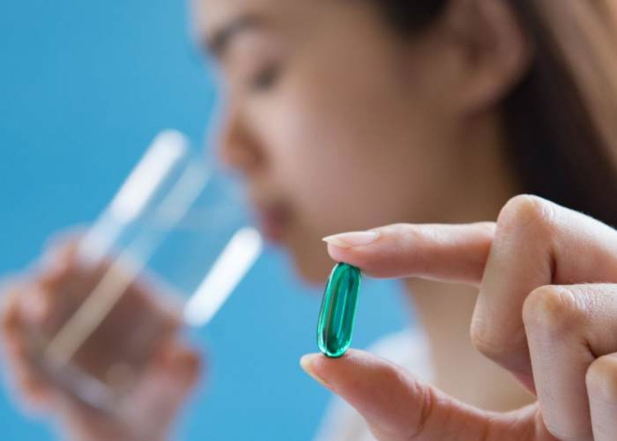 Mujer tomando agua y medicamento