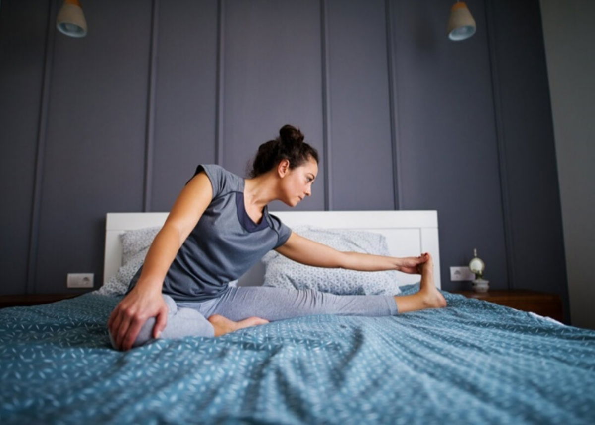 Mujer estiramiento cama
